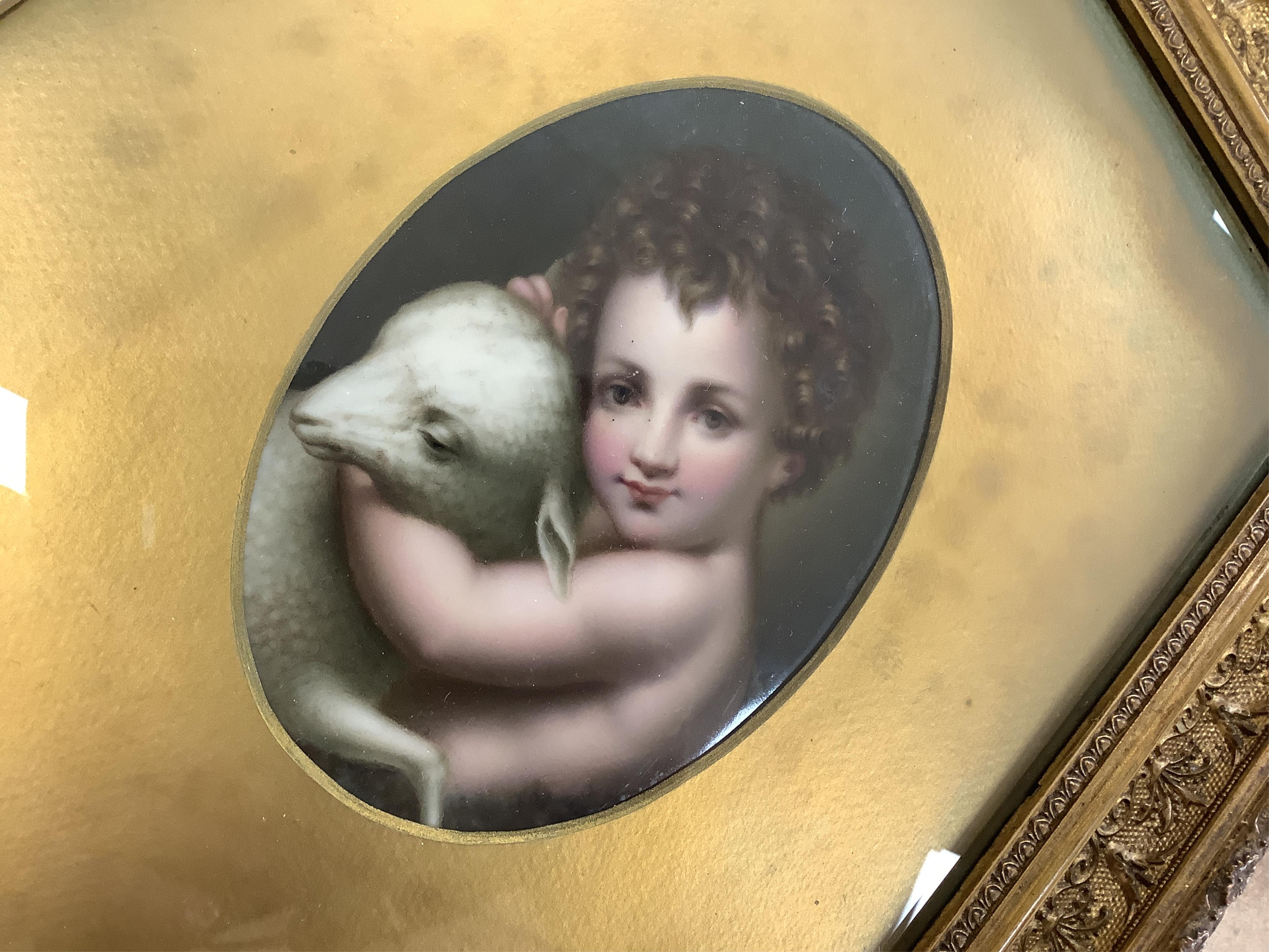 A German oval porcelain plaque with putto and lamb, possibly KPM, ornately gilt framed, overall 39 x 33cm. Condition - fair